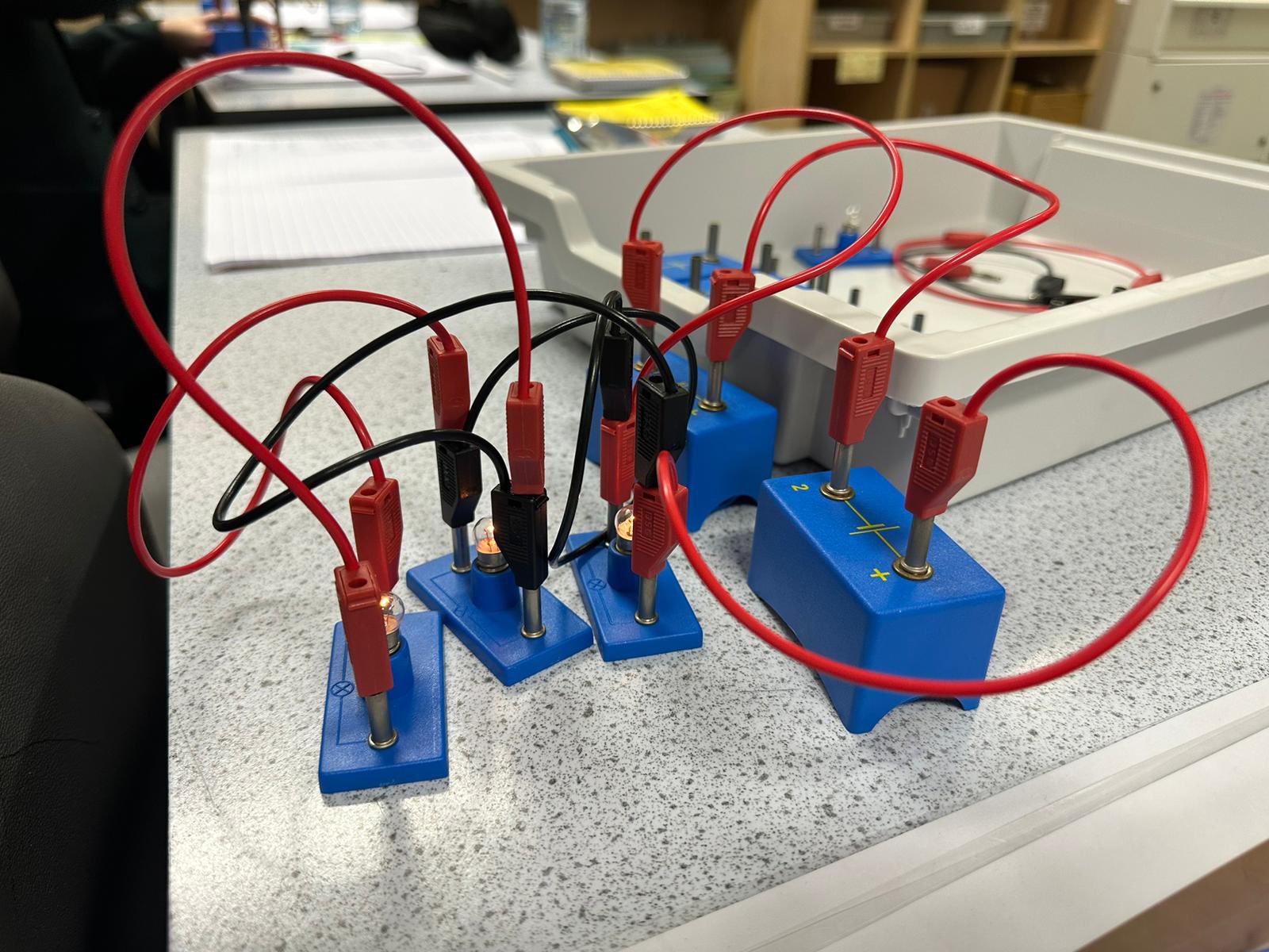 Scientists practising creating electrical circuits