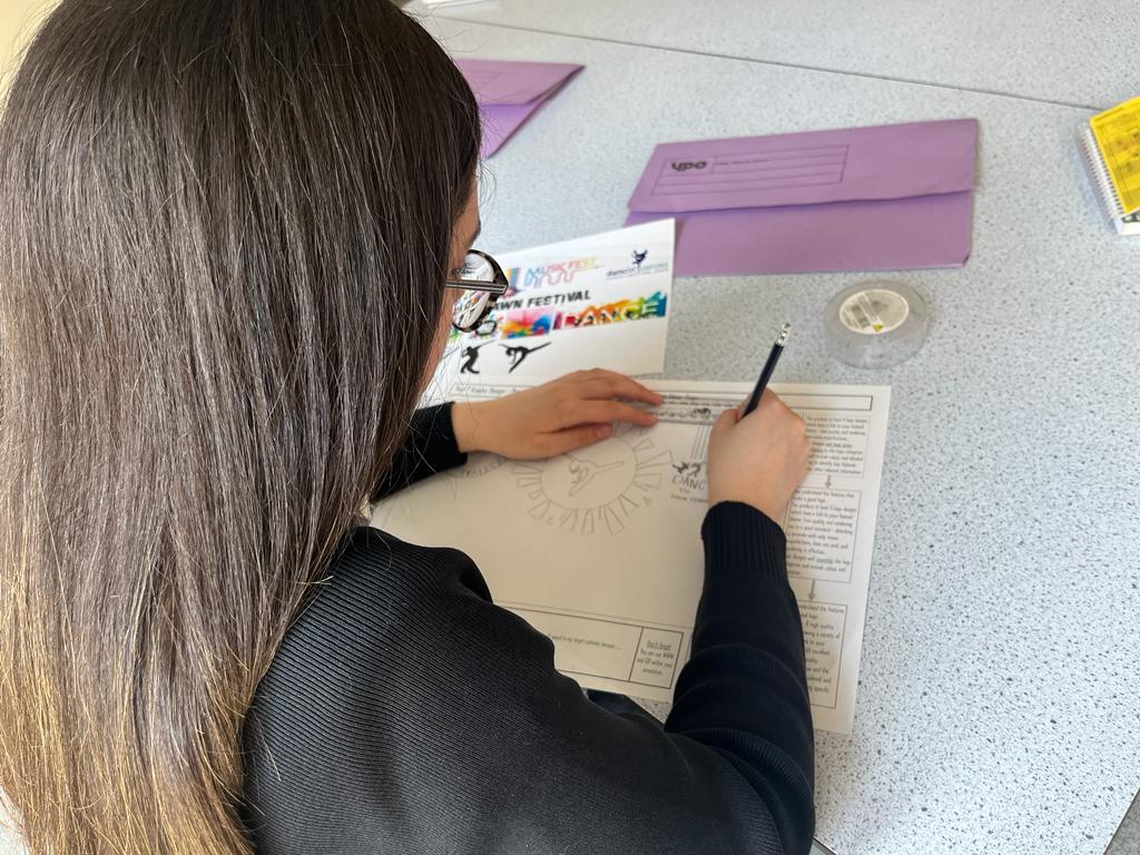 Y9 Graphics student making designs for a festival of their choice