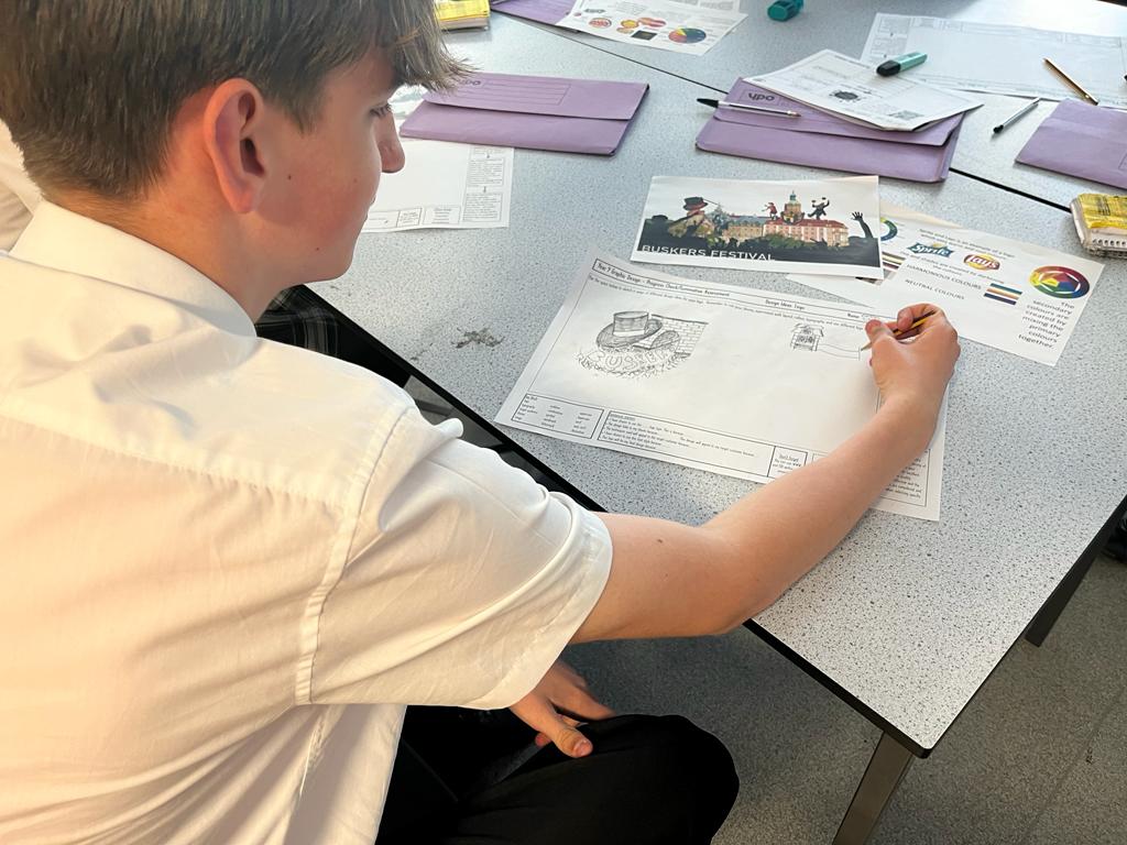 Y9 Graphics student making designs for a festival of their choice